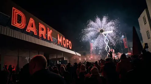 A crowd watching pyrotechnics under the red Dark Mofo neon sign at Night Mass: God Complex during Dark Mofo, Hobart, Tasmania