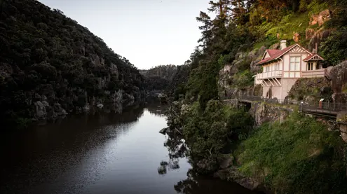 A heritage cottage on a rocky ledge above the river at Cataract Gorge Reserve, Launceston, Tasmania