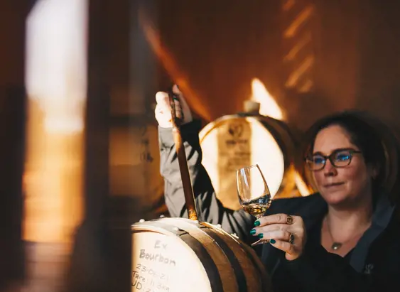 A distiller drawing whisky from a barrel at Killara Distillery, Richmond