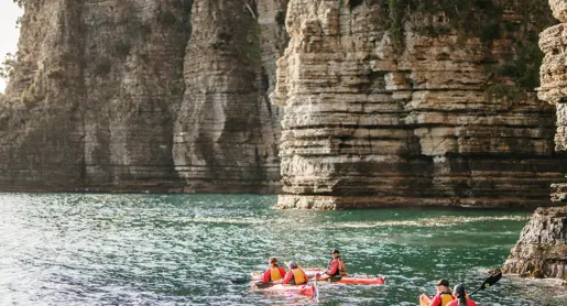 Sea kayakers paddle along dramatic coastal cliffs in Tasman National Park with Southern Sea Ventures