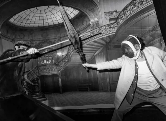 Black and white image of two people fencing with umbrellas in an ornate interior at The Secret Bank Society, Ringarooma