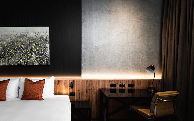 A photograph of the moodily lit rooms at verge, furnished with modern wood furniture.