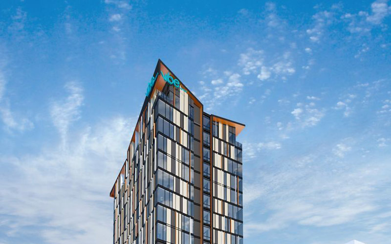 A photograph of the striking facade of the Vibe Hotel Hobart against a clear blue sky.